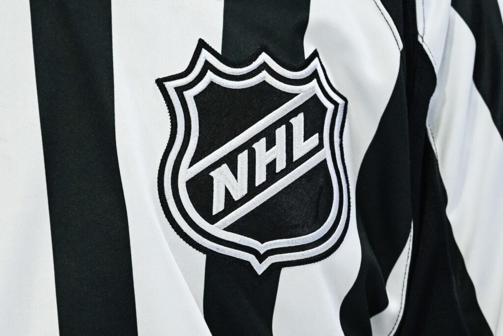 https://wpcms.predictionpro.com/uncategorized/auto-draft Pictured: View of an NHL logo on a jersey worn by a linesman.