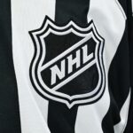https://wpcms.predictionpro.com/uncategorized/auto-draft Pictured: View of an NHL logo on a jersey worn by a linesman.
